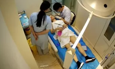 黑客破解美容医院手术室摄像头偷拍网红小美女一边刷视频一边露胸微整形美容打针瘦小脸