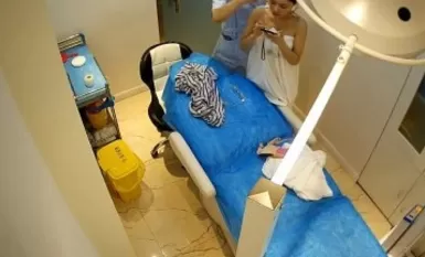 破解美容医院手术室摄像头偷拍网红小美女一边刷视频一边露胸微整